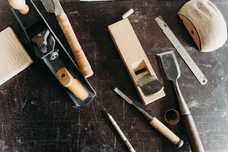 Woodworking hand tools laid out on a dark workbench, open-source making