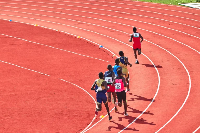 Runners racing on a red athletics track, sportswear in motion