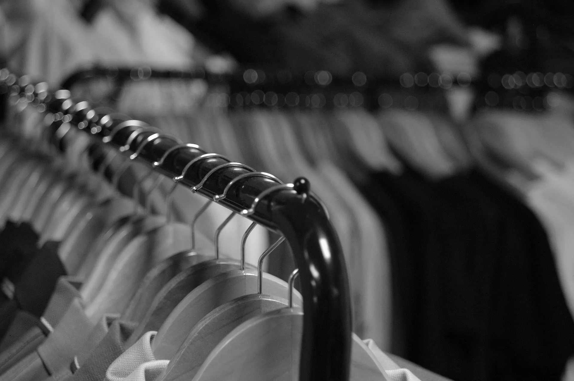 Black and white rail of garments on hangers, symbolising on-demand sportswear without overproduction