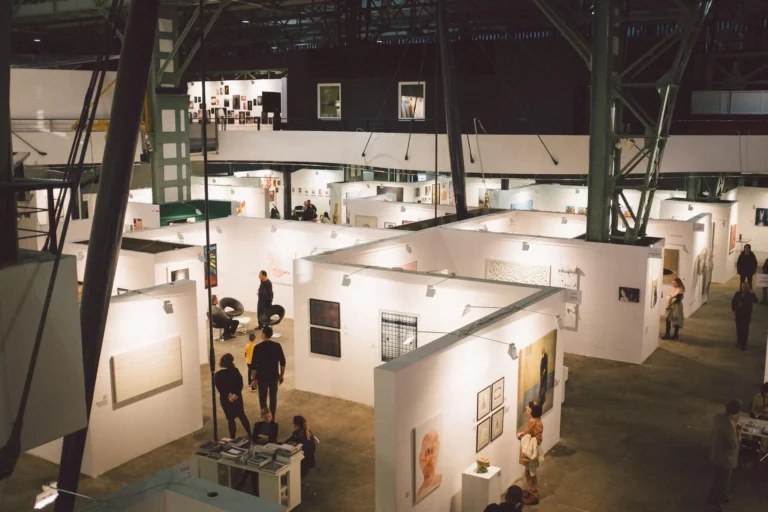 Exhibition hall with white booths seen from above, a textile trade fair setting