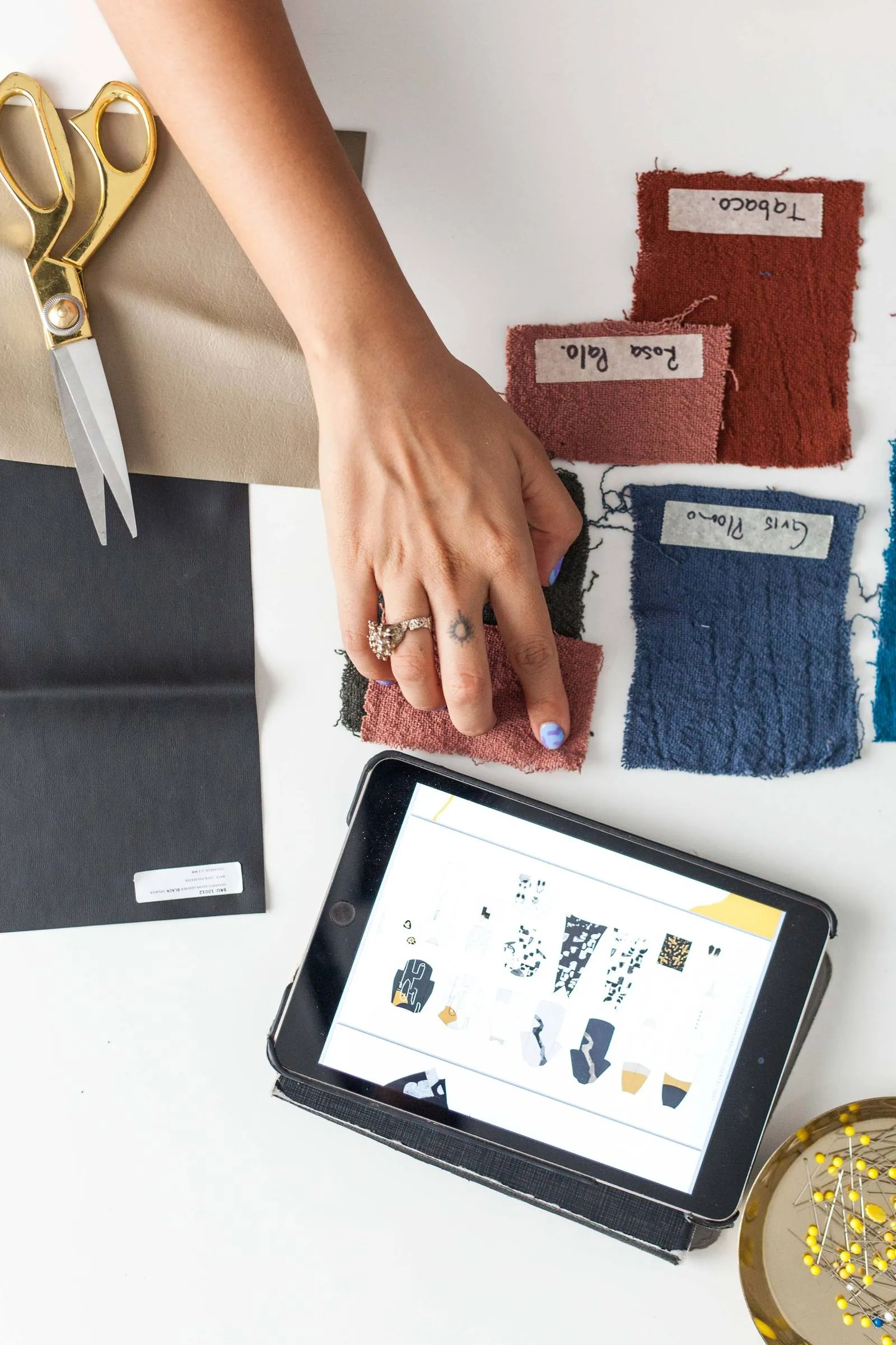 Fabric swatches next to a tablet showing design sketches for a custom cycling kit