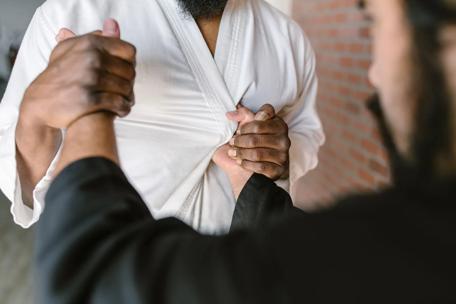 Close-up of a martial arts grip on training wear during a BJJ session