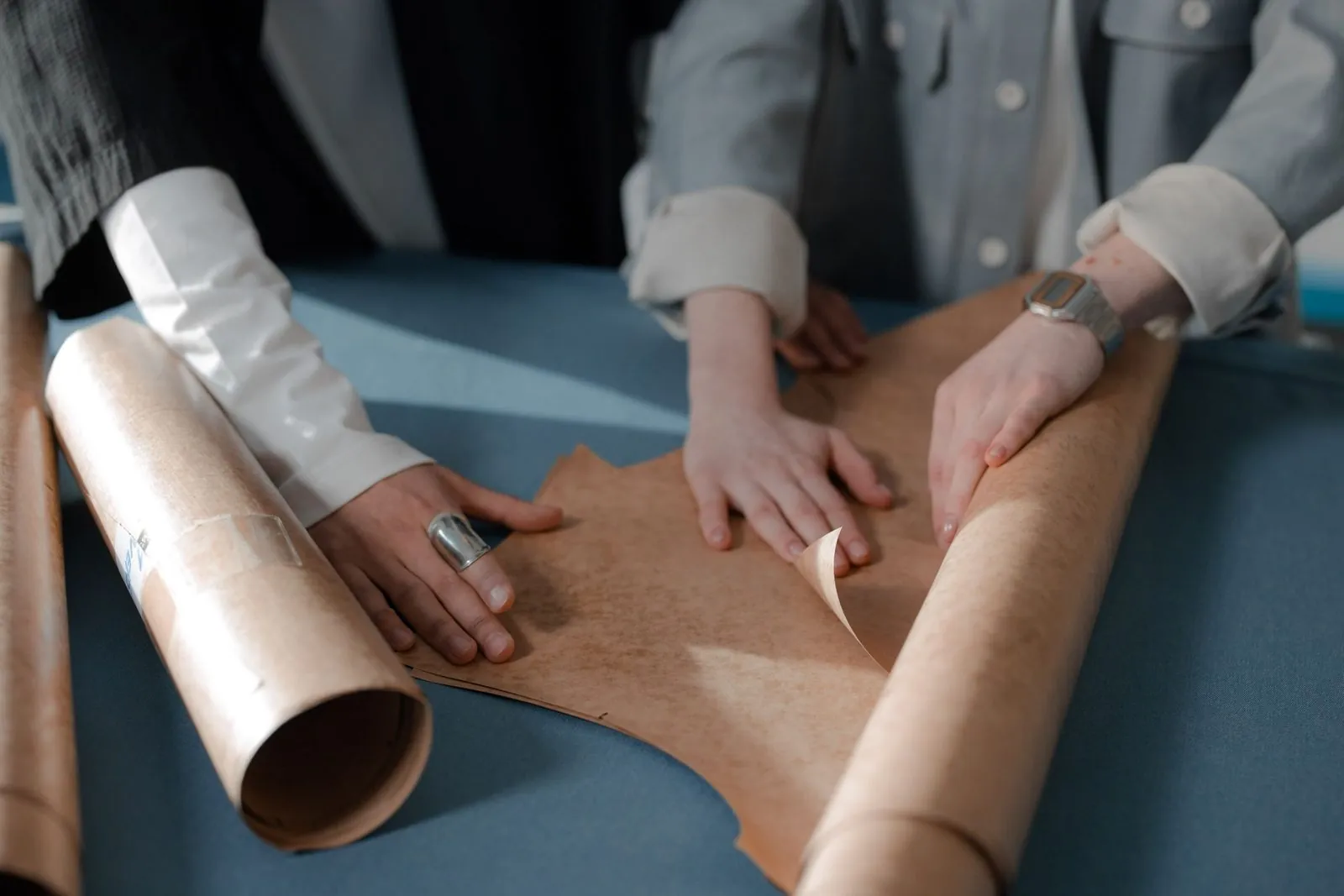 Hands working on a paper garment pattern, the basis of a private-label rashguard fit
