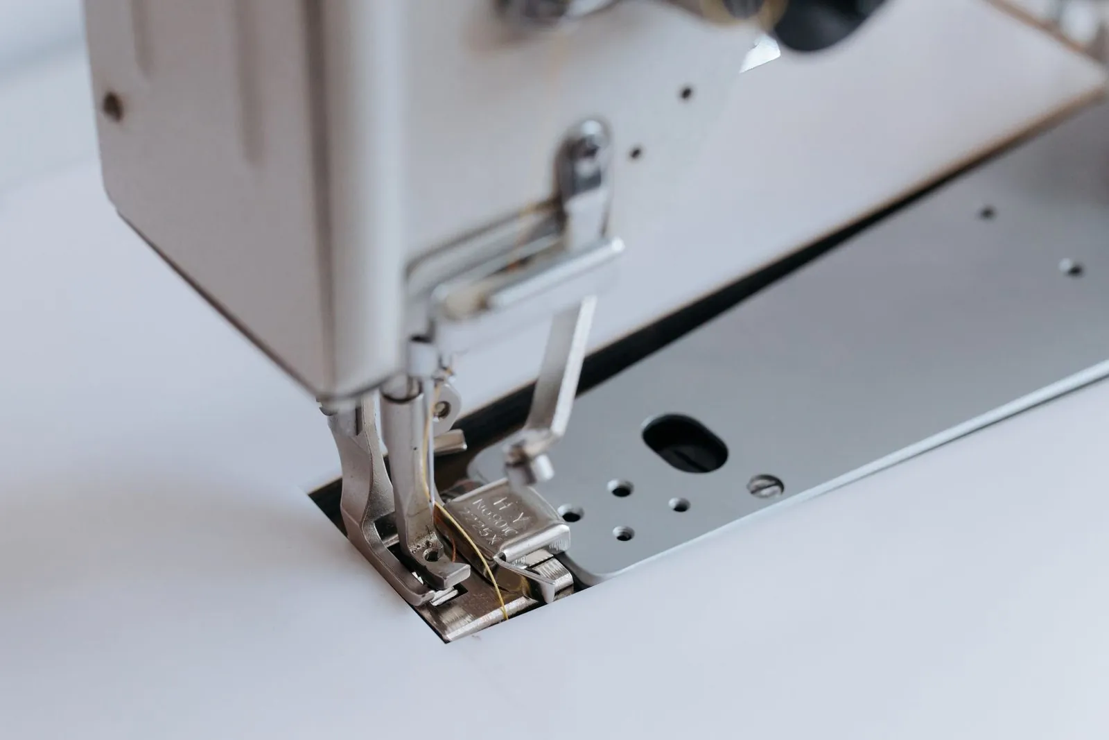 Close-up of a sewing machine presser foot and needle used in garment production