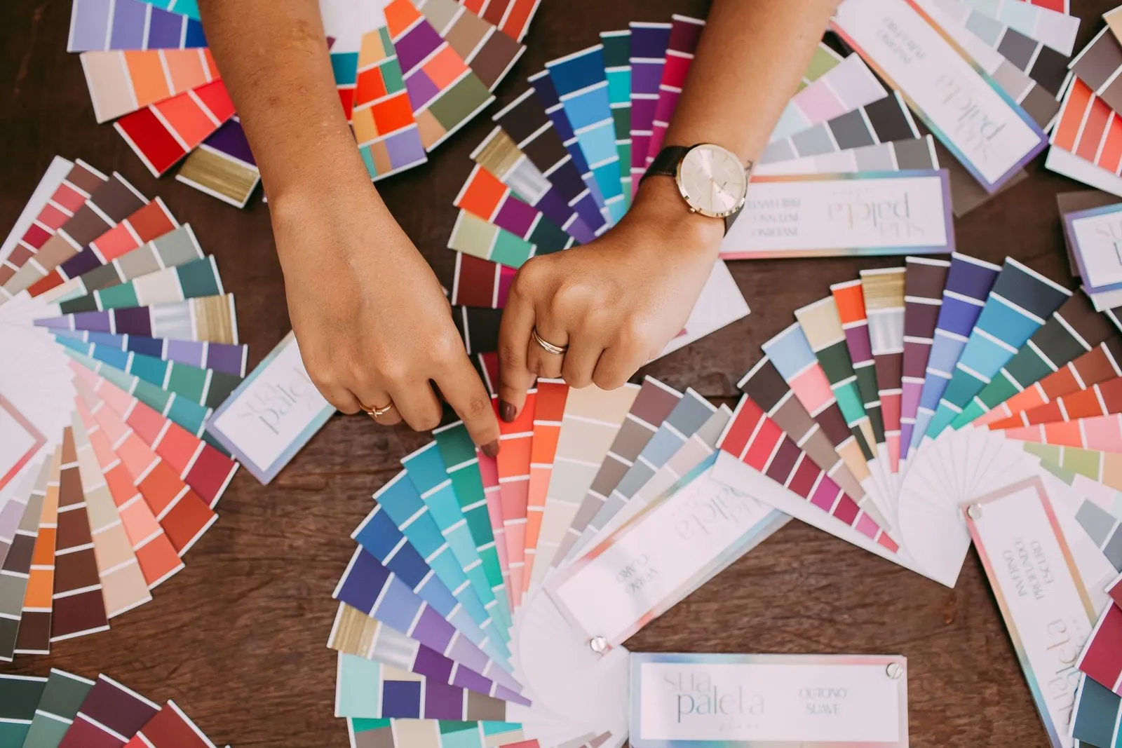 Hands choosing from colour swatches while planning a sublimated rashguard design
