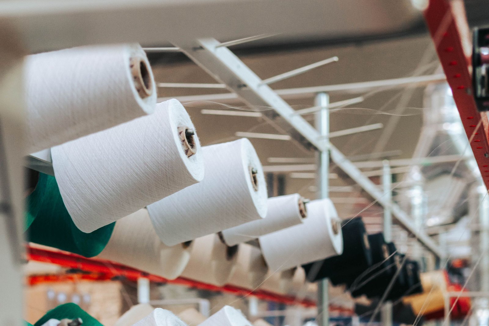 Rows of white and coloured yarn cones mounted on an industrial textile machine
